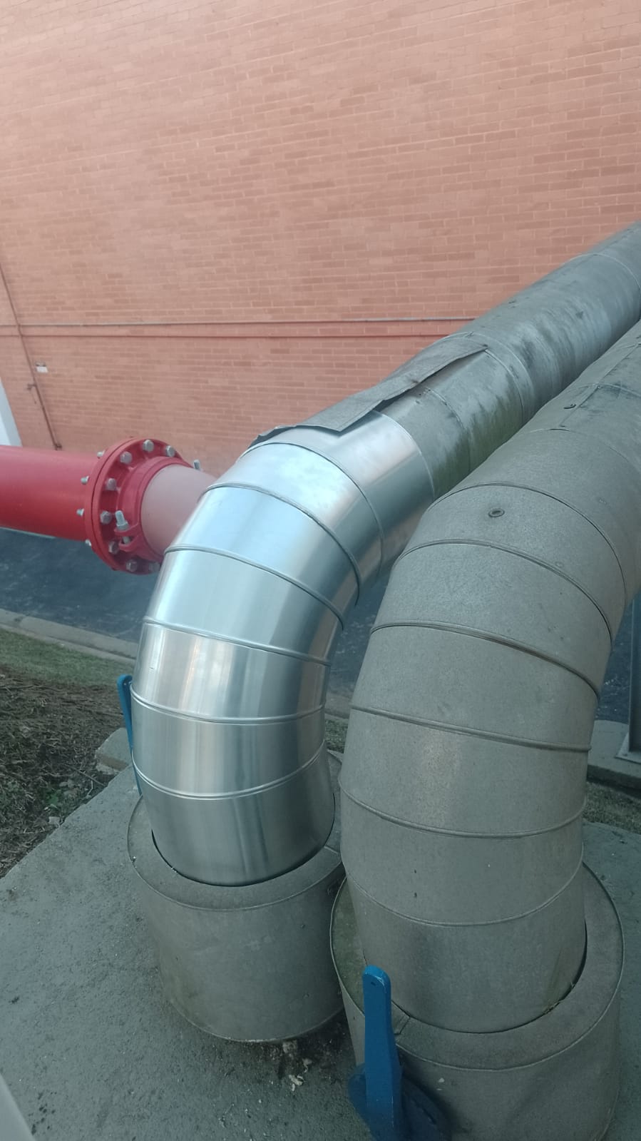 Acabamento em chapa de alumínio sobre curva de tubulação isolada